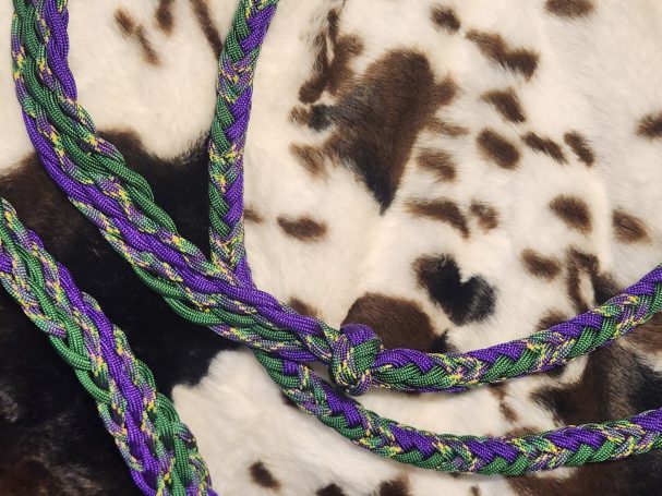 8 plait reins with purple, green and plum crazy. 8 cords flat with knots and an 8 square plait in between.